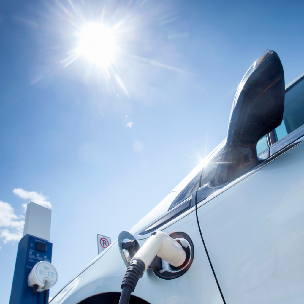 Samochód elektryczny podłączony do ładowarki, symbol dekarbonizacji transportu w Unii Europejskiej.