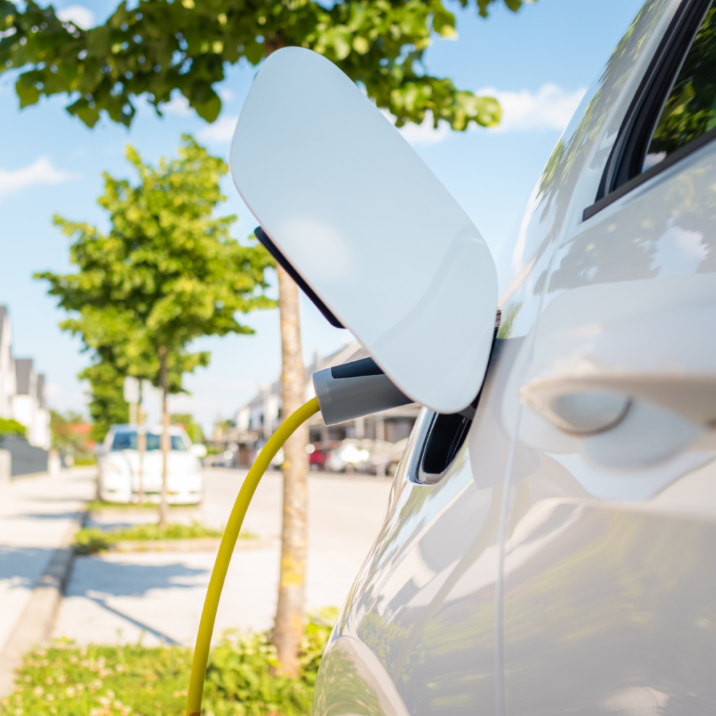 Samochód elektryczny podłączony do ładowarki, symbol dekarbonizacji transportu w Unii Europejskiej.