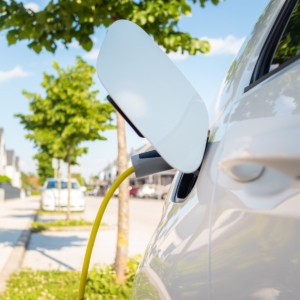 Samochód elektryczny podłączony do ładowarki, symbol dekarbonizacji transportu w Unii Europejskiej.